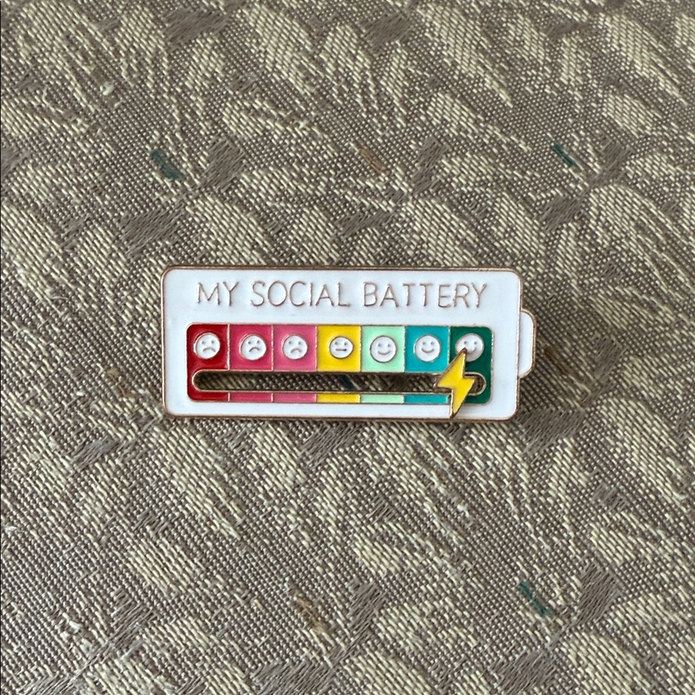 Free w/$25 purchase. One free item per cust. Colorful Social Battery Enamel Pin